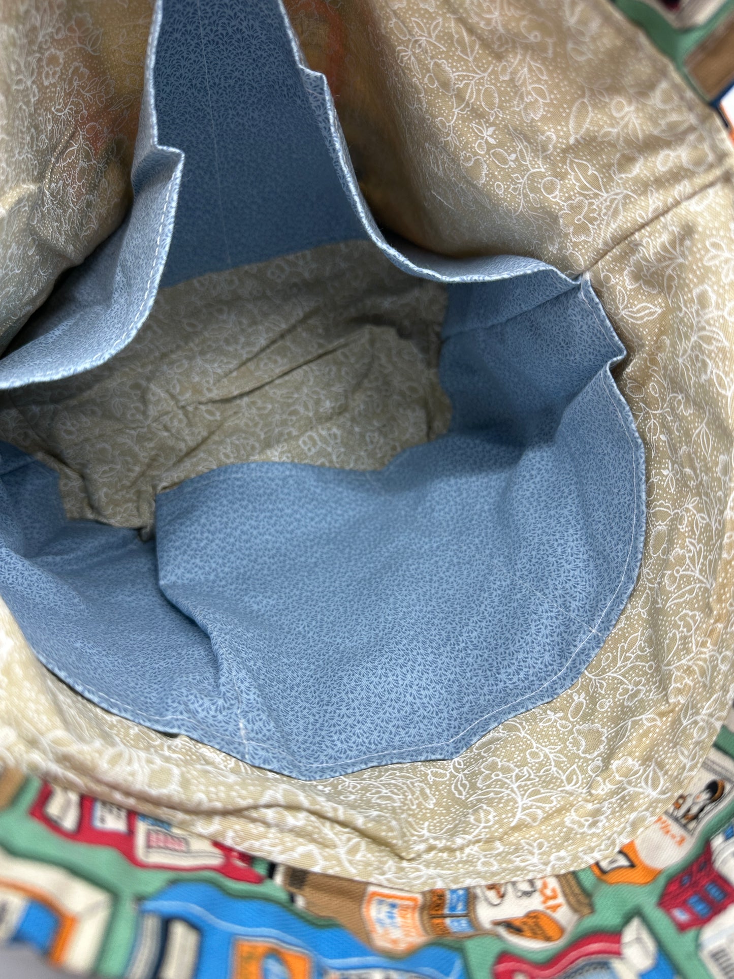 Interior shot of return vending machine Kato drawstring bag, showing that the lining is beige and the pockets are a light blue for contrast. There are five slip pockets in total.