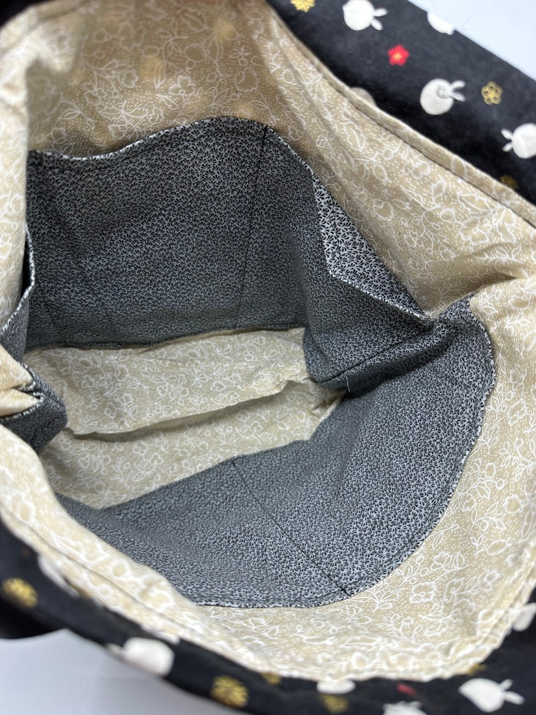 Open polka dot looking bunny bag showing beige interior with black pockets for contrast. There are five slip pockets total.